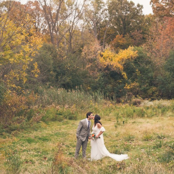 a married couple kissing outdoors.