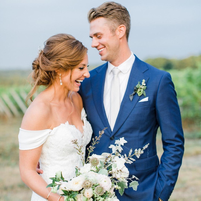 A man and woman pose for a wedding photo. They are looking at each other.